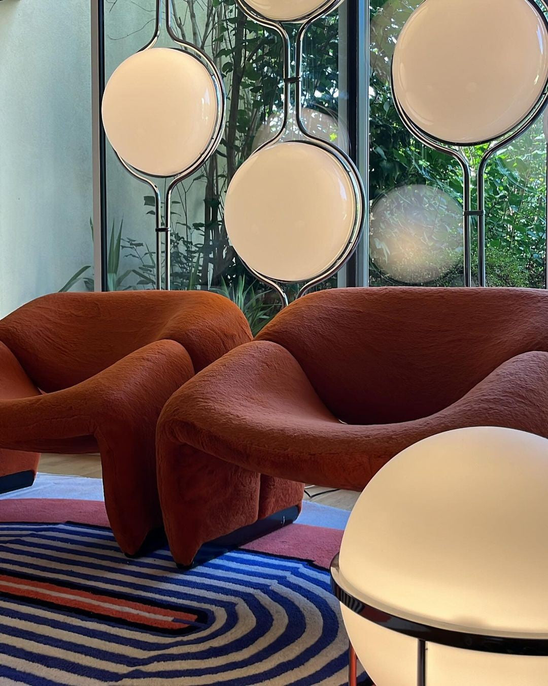 Pair_of_red_lounge_chairs_around_several_lamps