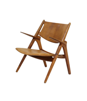 Hans_J._Wegner_CH28_“Sawbuck”_Armchair_in_Oak_and_Cognac_Leather,_1950s