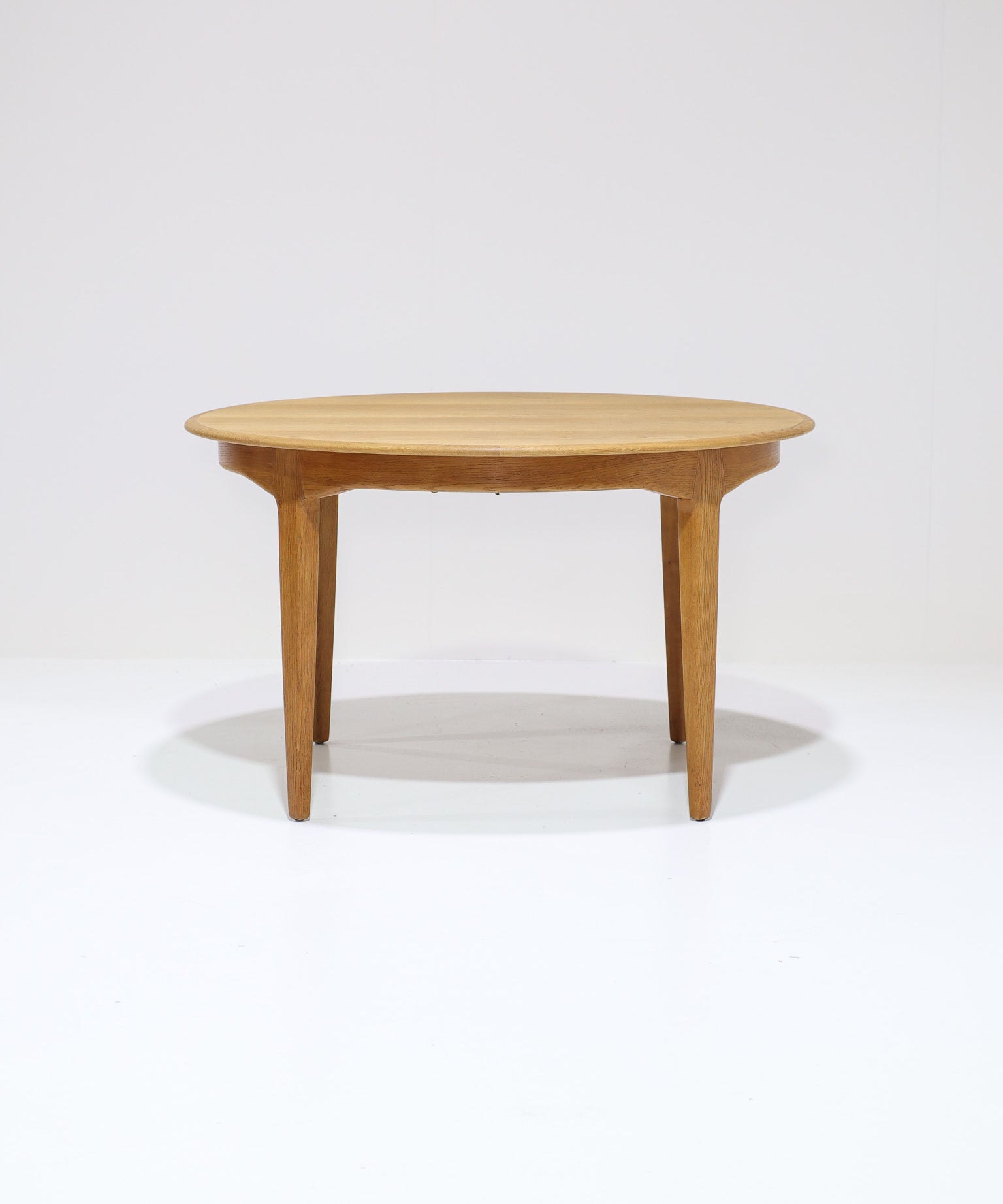 Henning_Kjaernulf_62_extendable_round_dining_table_for_Sorø_in_oak,_Denmark_1960s