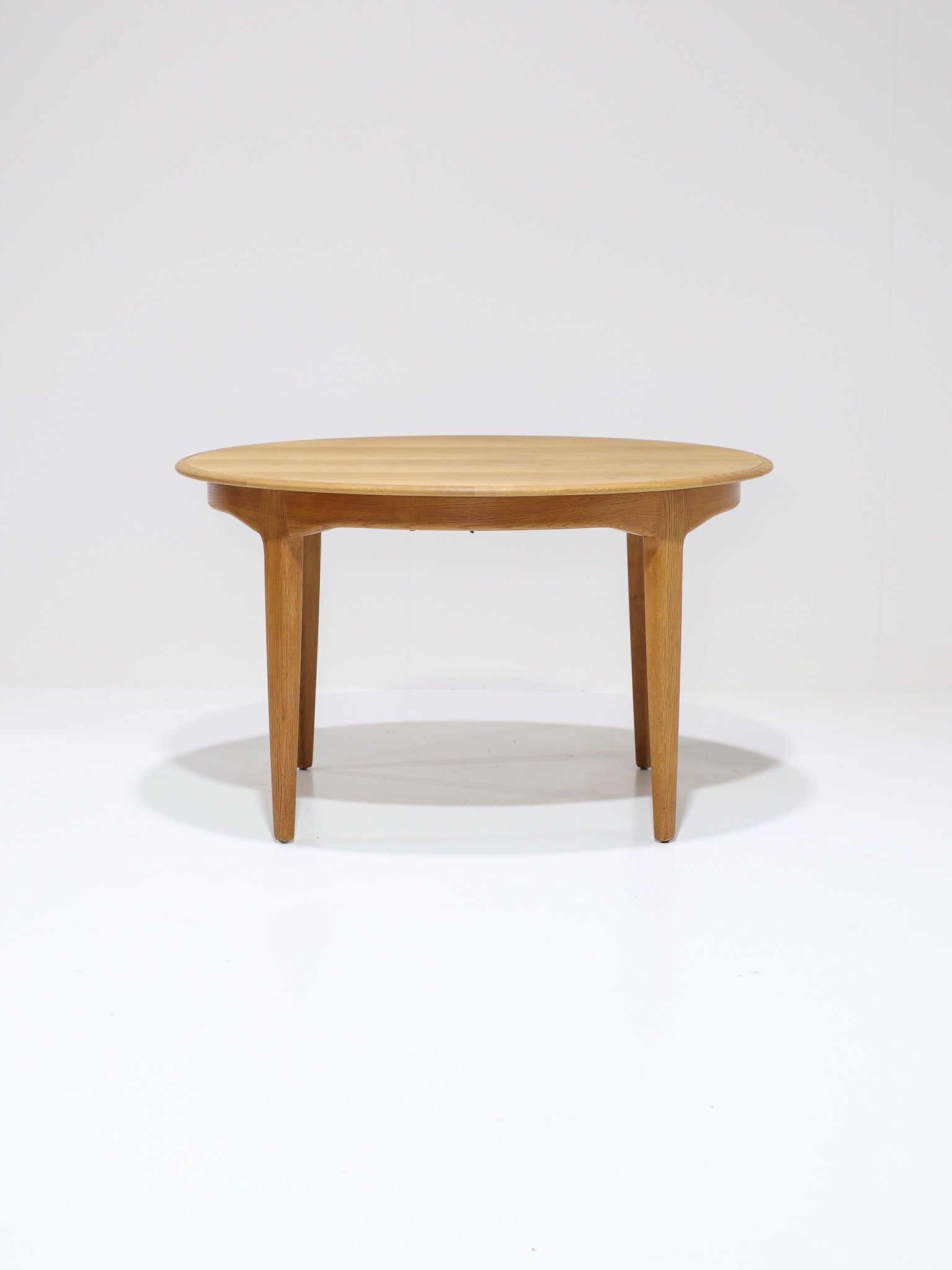Henning_Kjaernulf_62_extendable_round_dining_table_for_Sorø_in_oak,_Denmark_1960s
