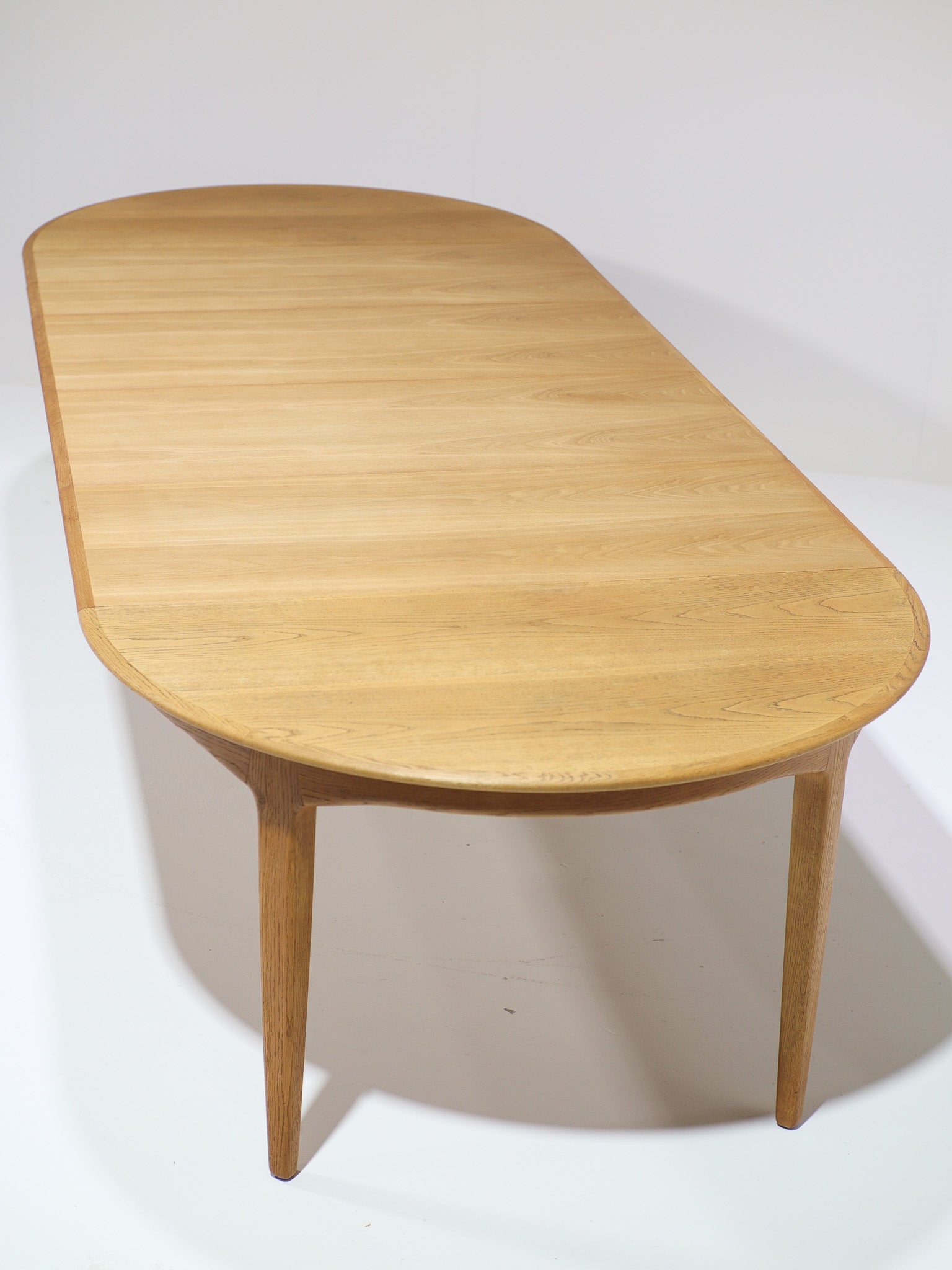 Henning_Kjaernulf_62_extendable_round_dining_table_for_Sorø_in_oak,_Denmark_1960s