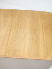 Henning_Kjaernulf_62_extendable_round_dining_table_for_Sorø_in_oak,_Denmark_1960s
