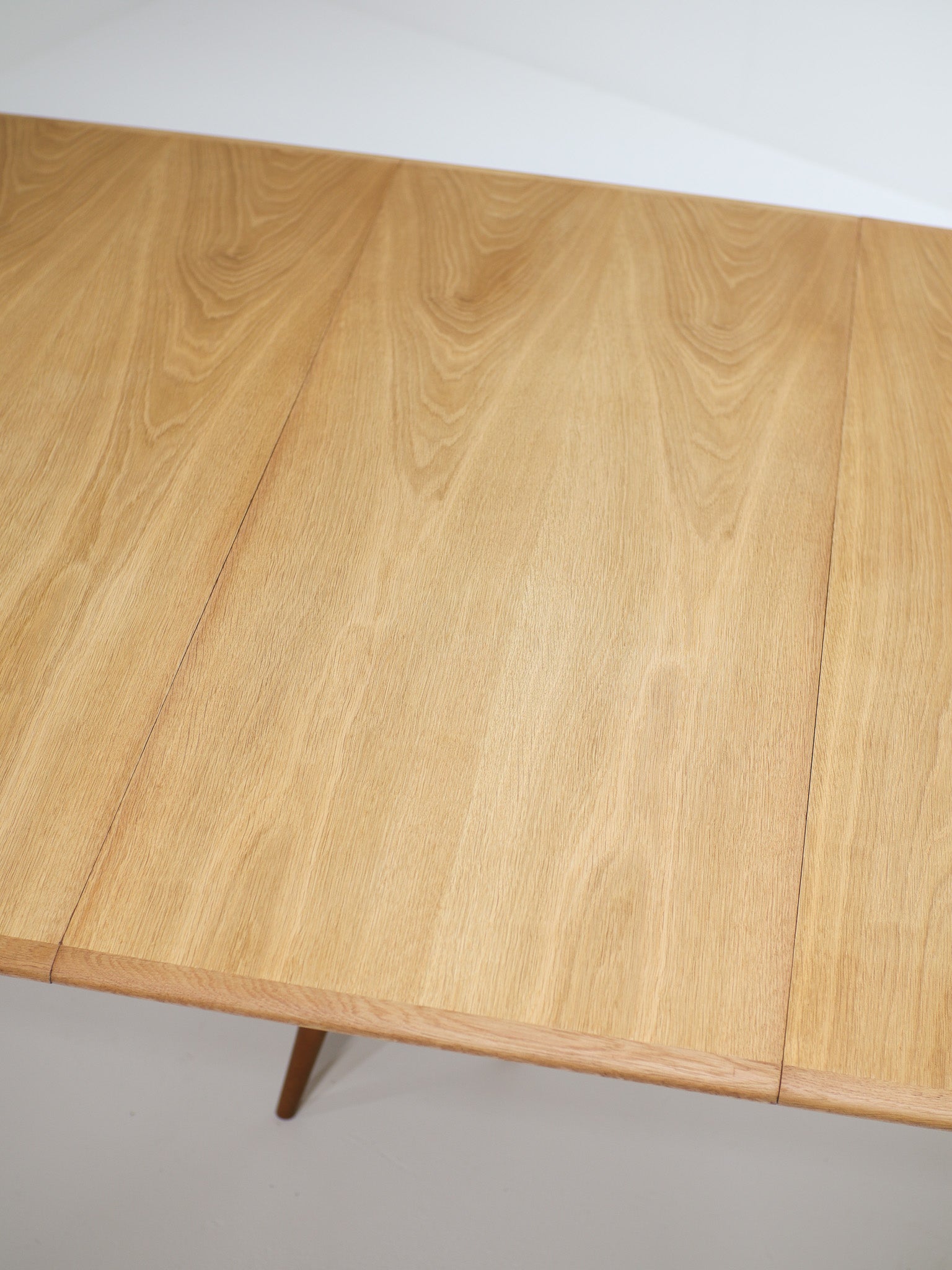 Henning_Kjaernulf_62_extendable_round_dining_table_for_Sorø_in_oak,_Denmark_1960s