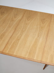 Henning_Kjaernulf_62_extendable_round_dining_table_for_Sorø_in_oak,_Denmark_1960s