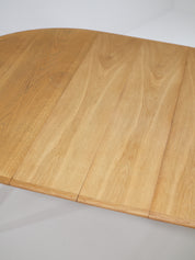 Henning_Kjaernulf_62_extendable_round_dining_table_for_Sorø_in_oak,_Denmark_1960s
