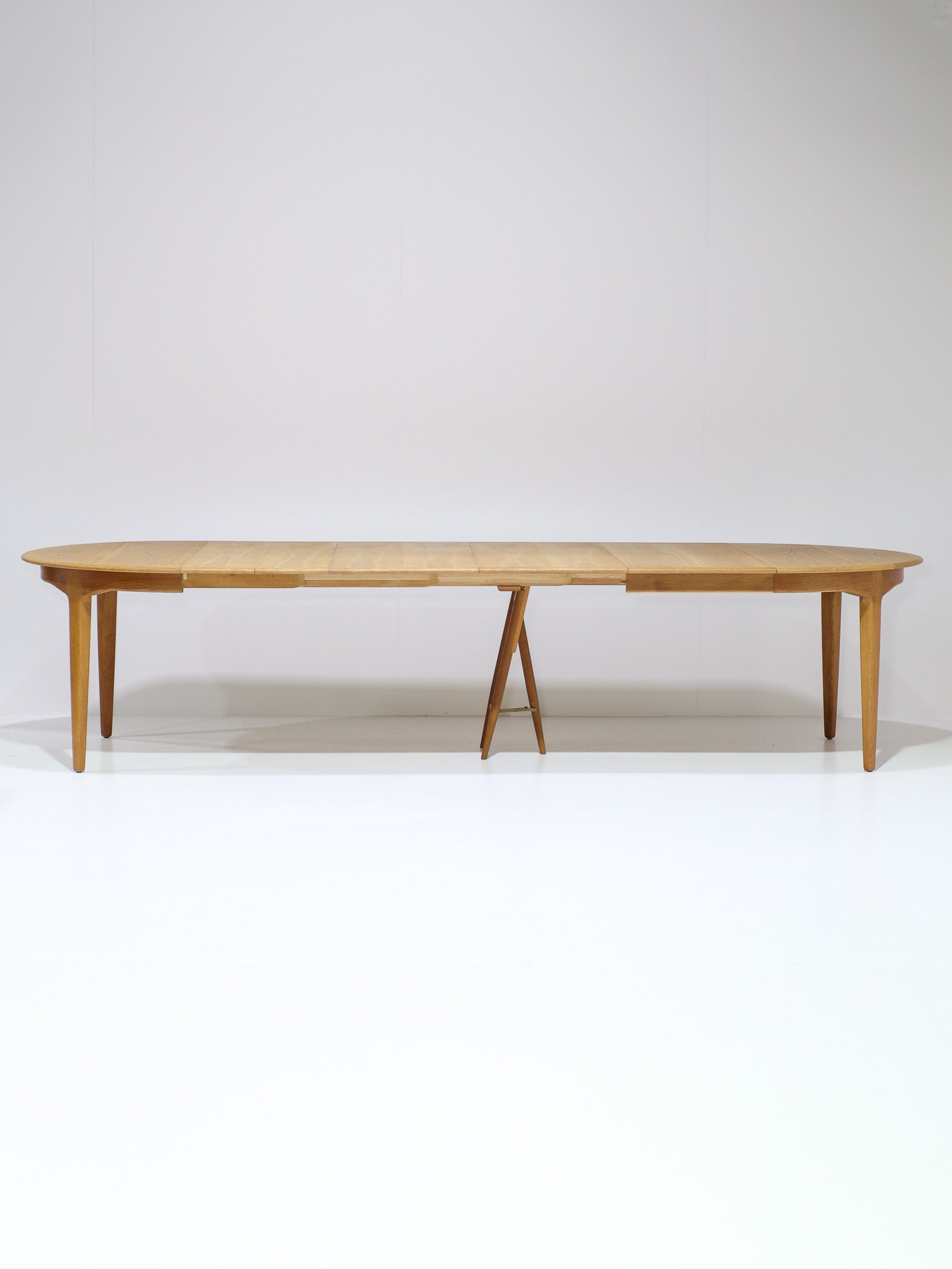 Henning_Kjaernulf_62_extendable_round_dining_table_for_Sorø_in_oak,_Denmark_1960s