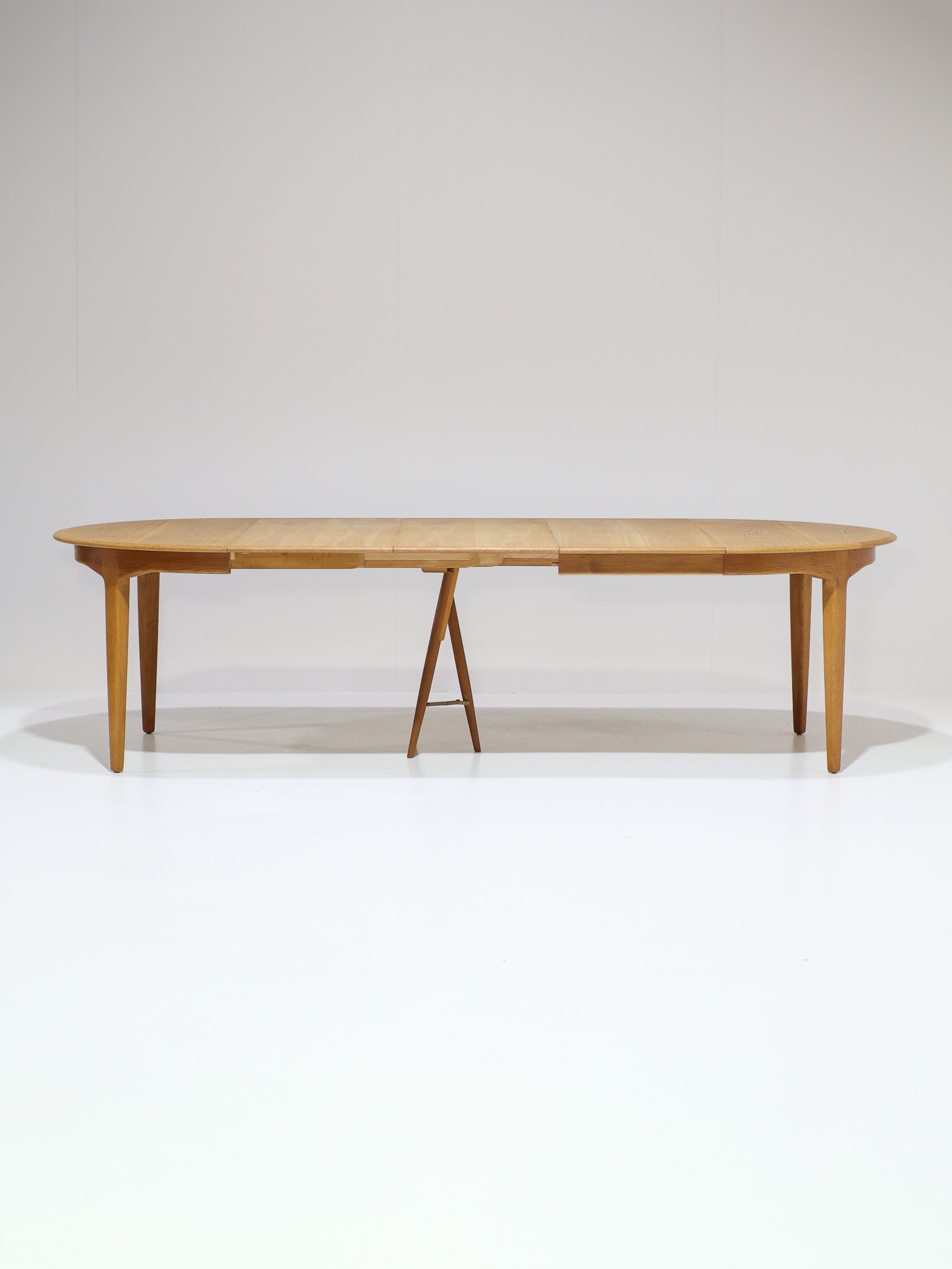Henning_Kjaernulf_62_extendable_round_dining_table_for_Sorø_in_oak,_Denmark_1960s