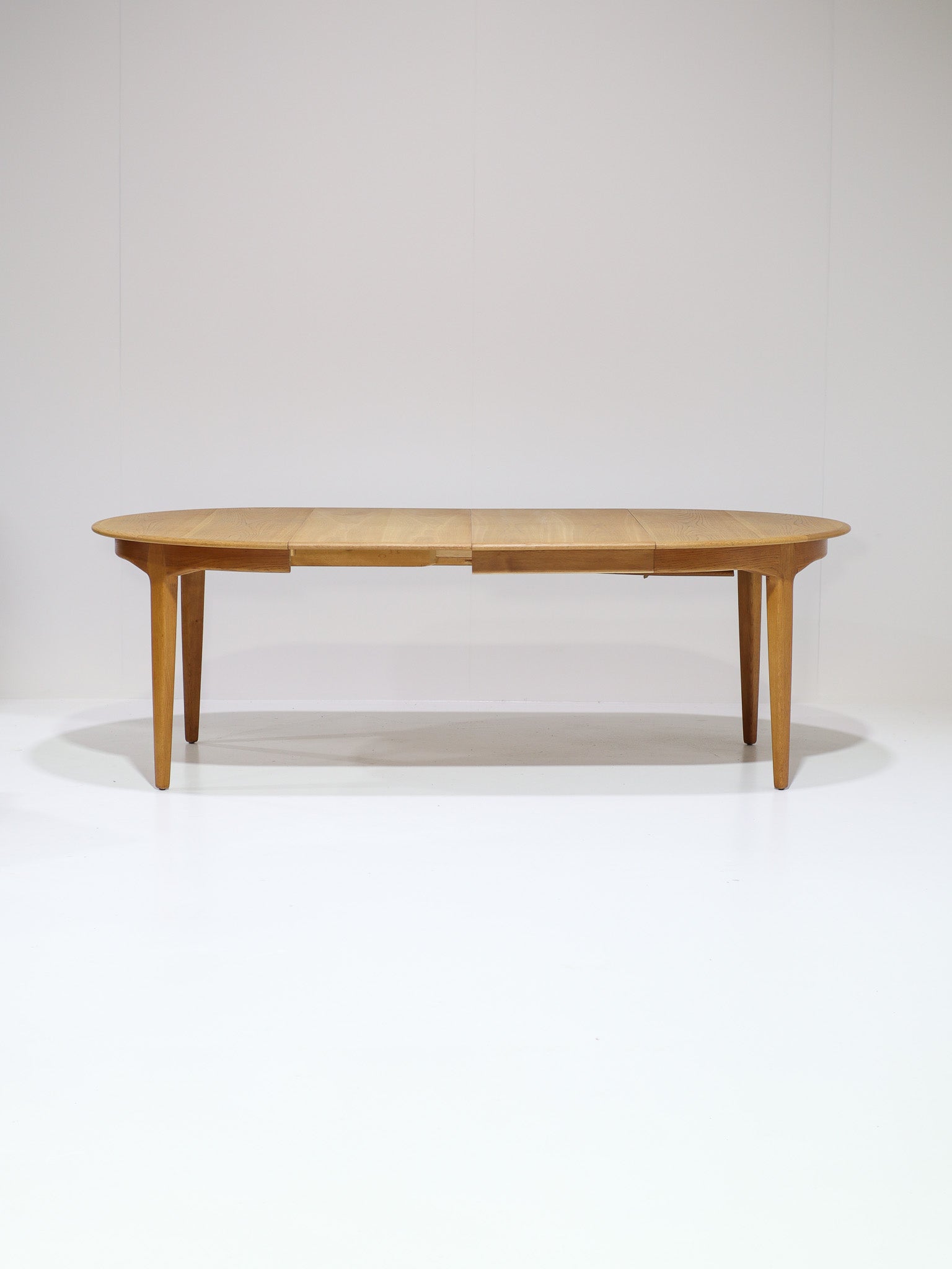 Henning_Kjaernulf_62_extendable_round_dining_table_for_Sorø_in_oak,_Denmark_1960s