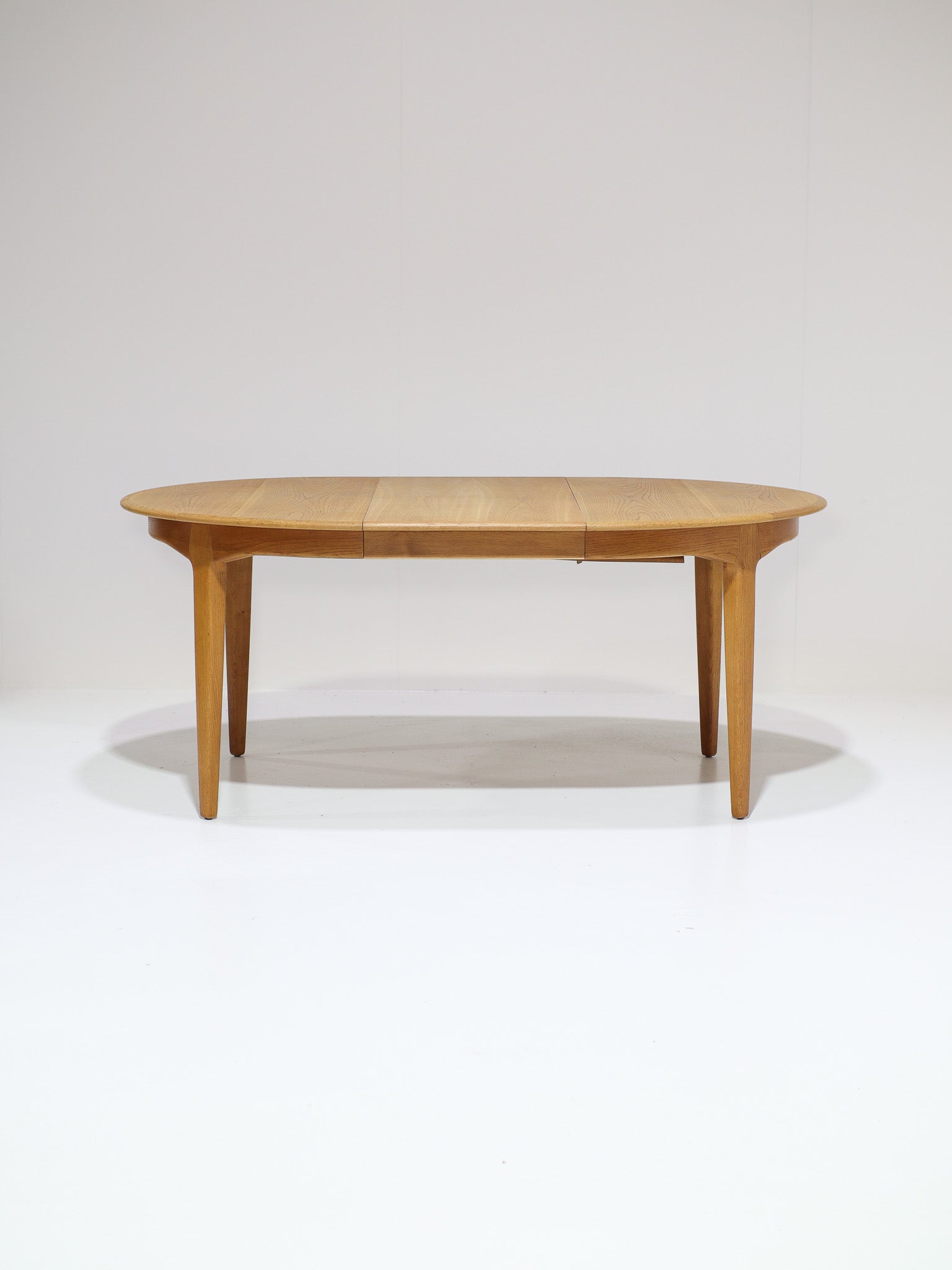 Henning_Kjaernulf_62_extendable_round_dining_table_for_Sorø_in_oak,_Denmark_1960s
