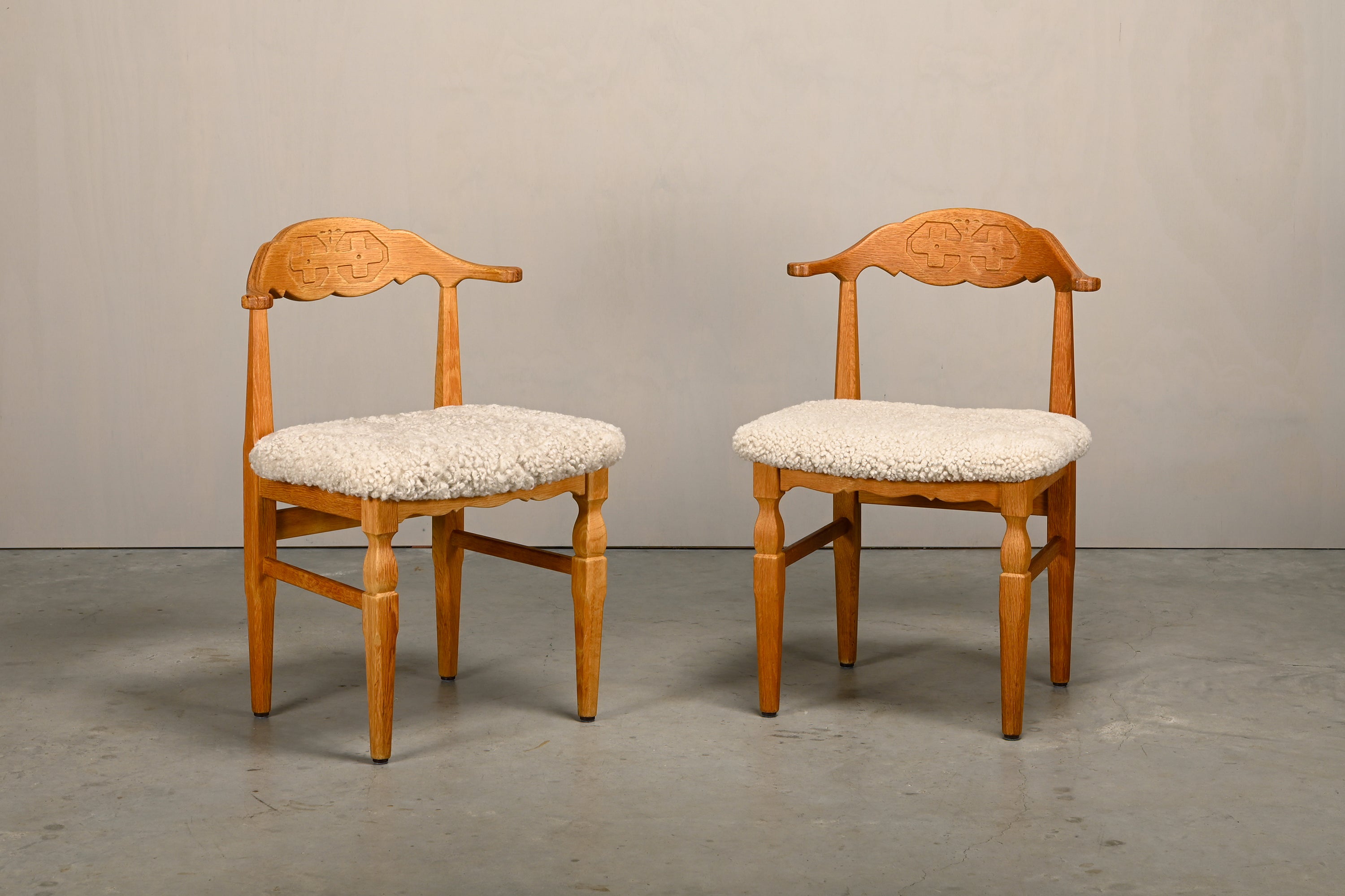 Set_of_8_Brutalist_Oak_Dining_Chairs_by_Henning_Kjærnulf_for_EG_Kvalitetsmøbel,_Off-White_Sheepskin,_Denmark,_1960s