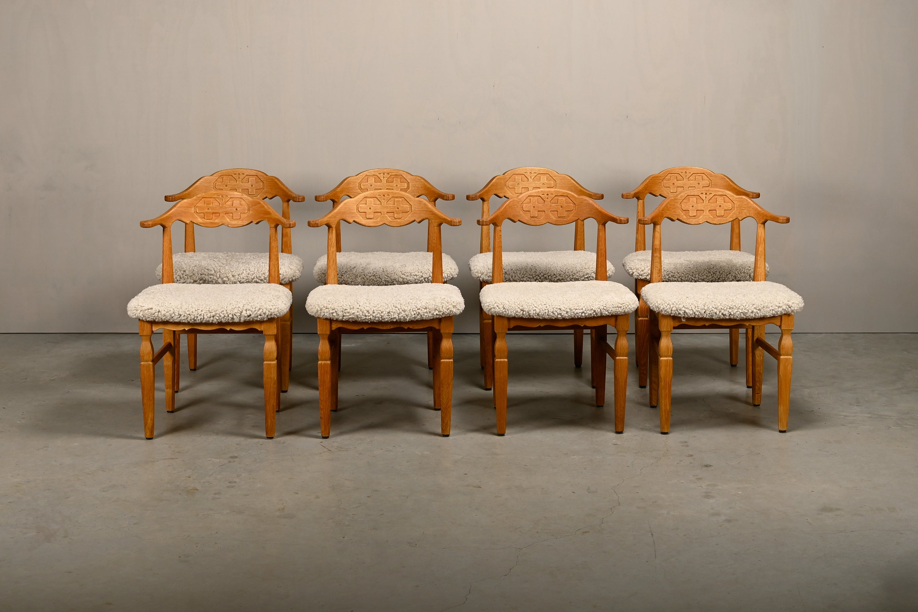 Set_of_8_Brutalist_Oak_Dining_Chairs_by_Henning_Kjærnulf_for_EG_Kvalitetsmøbel,_Off-White_Sheepskin,_Denmark,_1960s