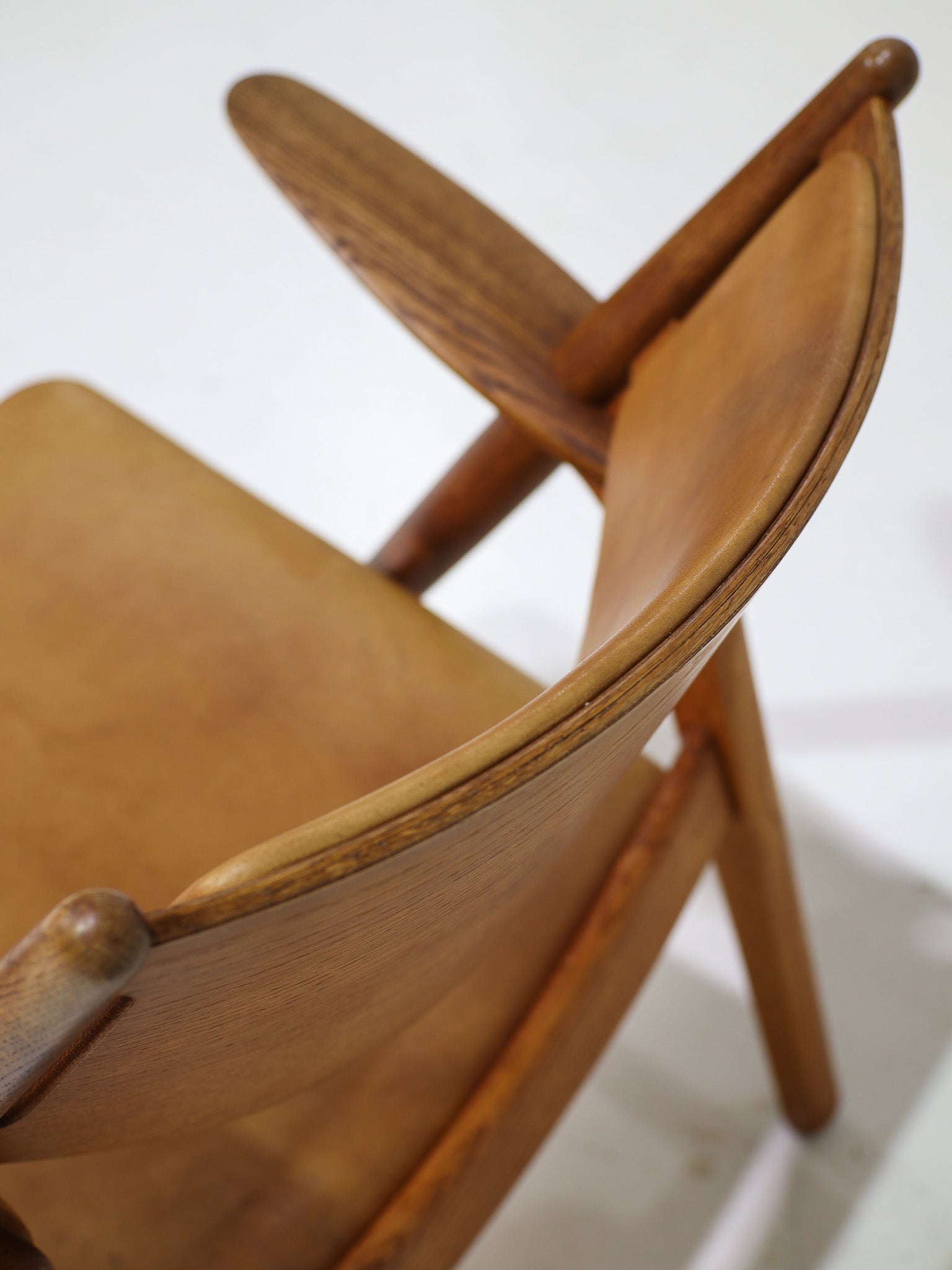 Hans_J._Wegner_CH28_“Sawbuck”_Armchair_in_Oak_and_Cognac_Leather,_1950s