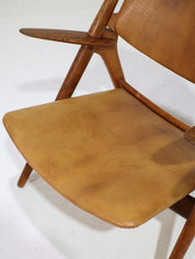 Hans_J._Wegner_CH28_“Sawbuck”_Armchair_in_Oak_and_Cognac_Leather,_1950s
