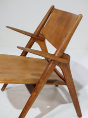 Hans_J._Wegner_CH28_“Sawbuck”_Armchair_in_Oak_and_Cognac_Leather,_1950s