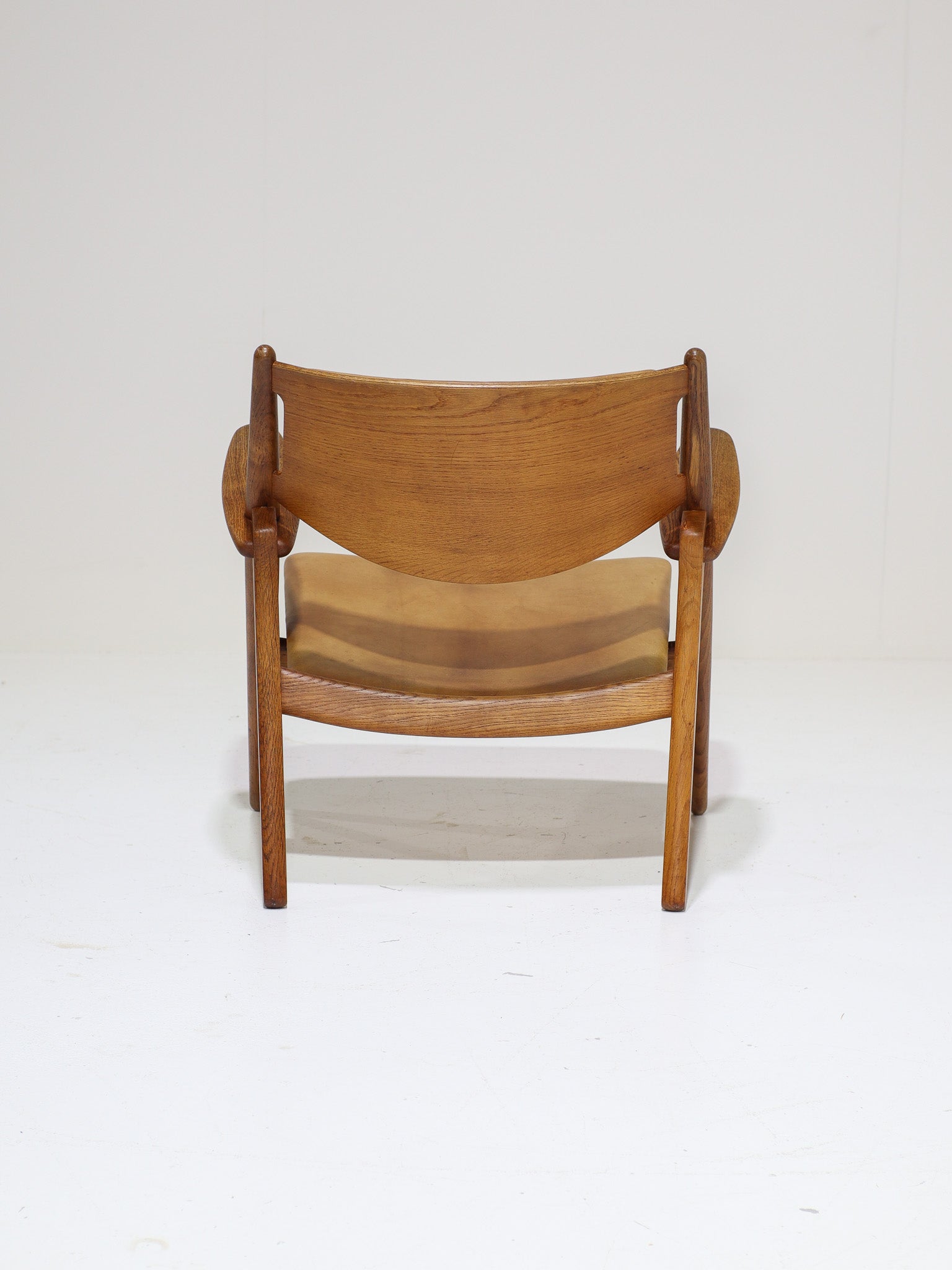 Hans_J._Wegner_CH28_“Sawbuck”_Armchair_in_Oak_and_Cognac_Leather,_1950s