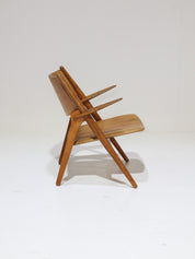 Hans_J._Wegner_CH28_“Sawbuck”_Armchair_in_Oak_and_Cognac_Leather,_1950s
