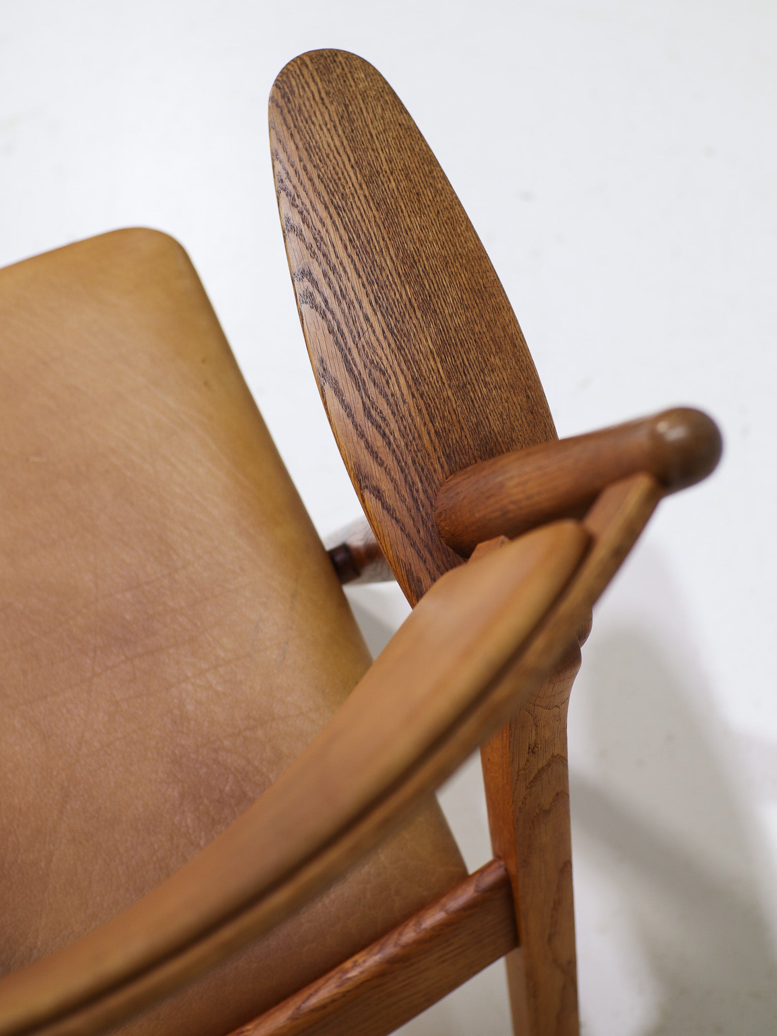 Hans_J._Wegner_CH28_“Sawbuck”_Armchair_in_Oak_and_Cognac_Leather,_1950s