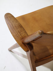 Hans_J._Wegner_CH28_“Sawbuck”_Armchair_in_Oak_and_Cognac_Leather,_1950s