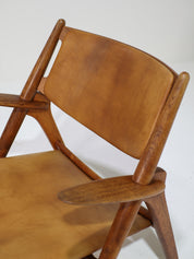 Hans_J._Wegner_CH28_“Sawbuck”_Armchair_in_Oak_and_Cognac_Leather,_1950s