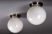 Set_of_2_Paavo_Tynell_Opaline_Glass_Sphere_Flush_Mount_Lamps,_1930s